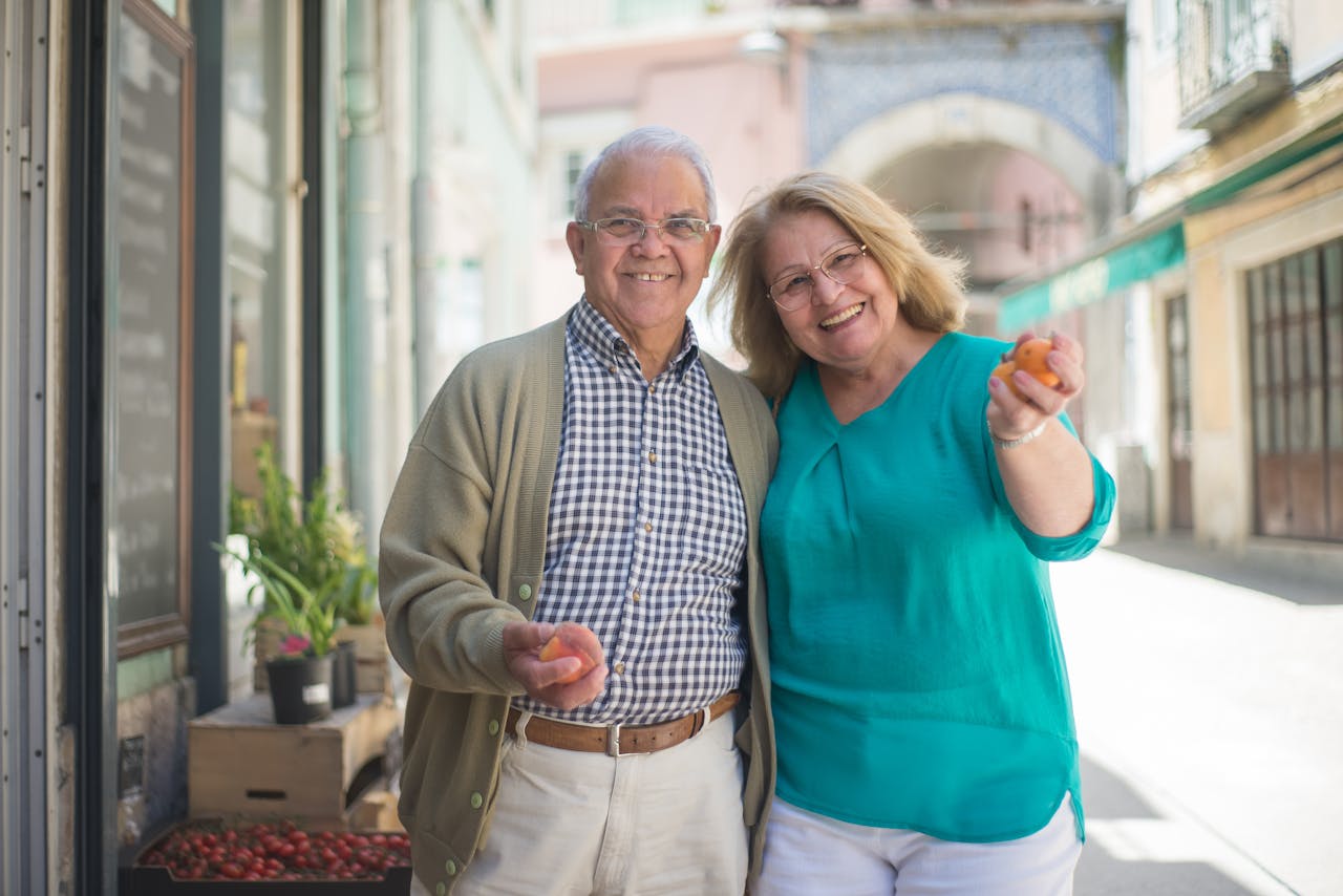 Smiling senior couple enjoying a day out shopping in a sunny Portuguese street.